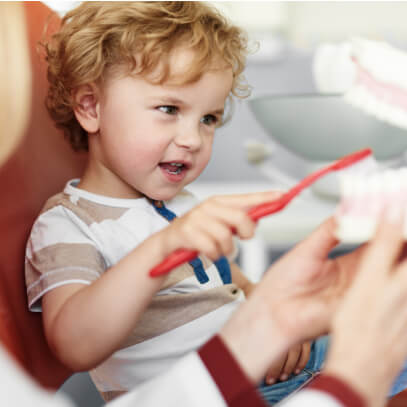 Little boy practicing tooth brushing at the dentist's