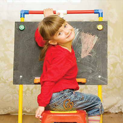 Young girl coloring on a chalk board