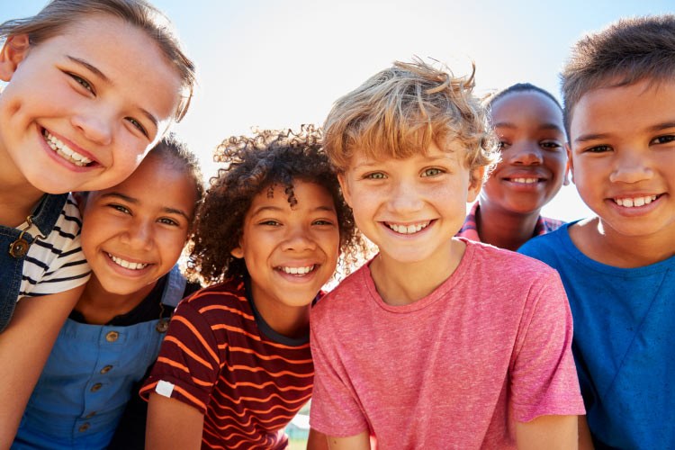 A group of multiracial children smile after receiving emergency dental care