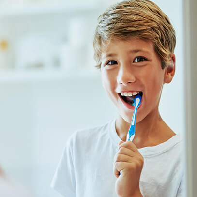 Happy boy brushing his teeth