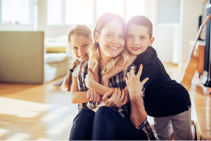 Mom smiles with her two children without decay and cavities in Tyler, TX