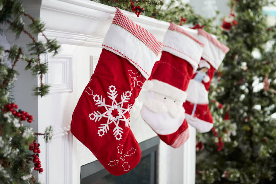 Closeup of red stockings hanging on the fireplace mantle waiting for Christmas stocking stuffers for kids