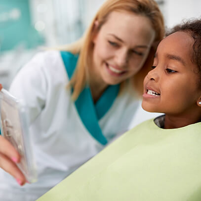 girl at the dentist looking in mirror