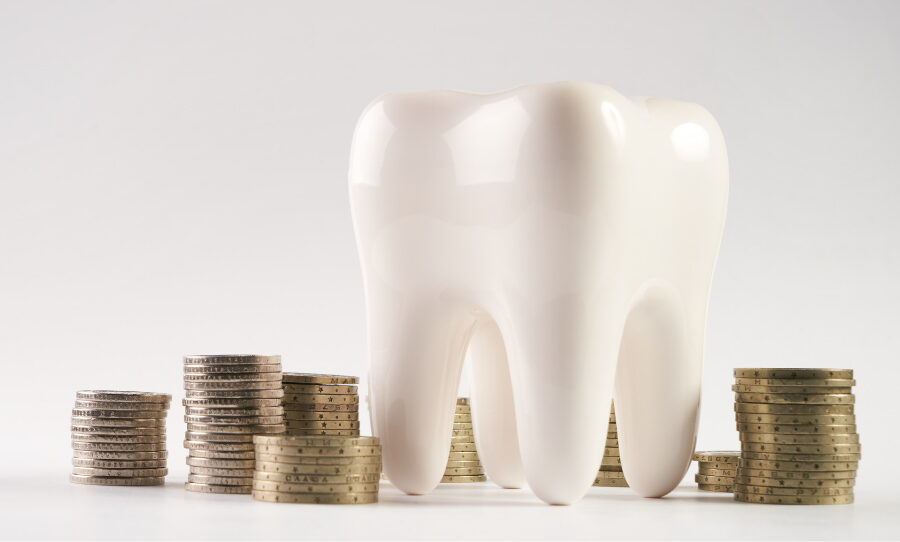 A tooth next to piles of coins for a blog post about how to pay for a child's dental emergency