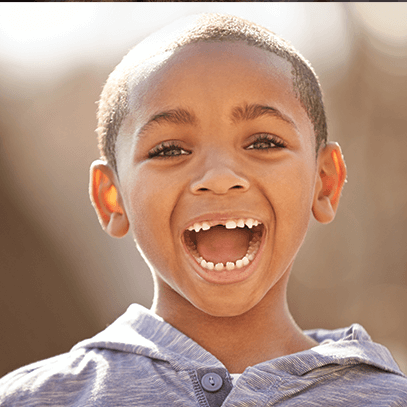 boy smiles with missing tooth