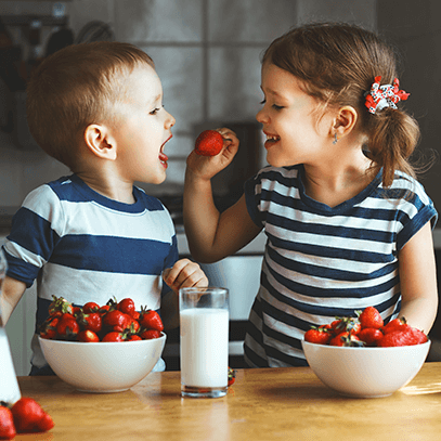 siblings eating strawberries
