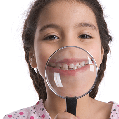 girl holding magnifying glass over her teeth