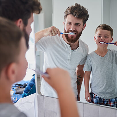 father and son brushing their teeth together